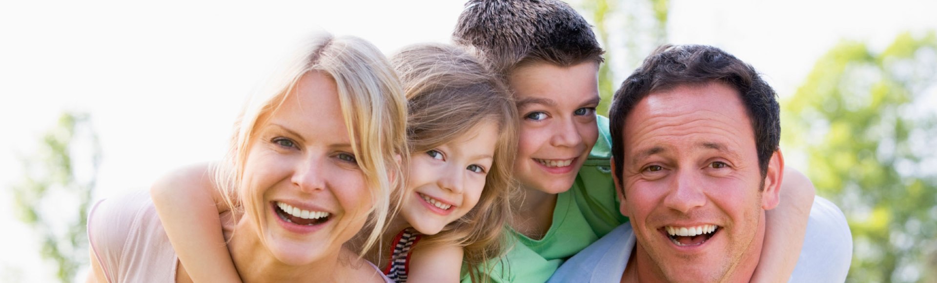 Eltern tragen zwei Kinder huckepack, lachend, © istockphoto.com©monkeybusinessimages